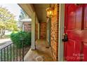 Brick front porch with red door and lantern light at 3119 Suffolk Dr, Shelby, NC 28152