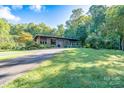 Ranch style home with a long driveway and green lawn at 501 Journey Sw St, Concord, NC 28025