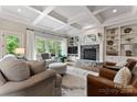 Bright living room with a stone fireplace, built-in shelving, and coffered ceiling at 235 Grey Rd, Davidson, NC 28036