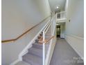 Clean carpeted stairwell with wooden handrail at 11719 Ridgeway Park Dr, Charlotte, NC 28277