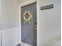 Gray front door with a floral wreath at 11719 Ridgeway Park Dr, Charlotte, NC 28277