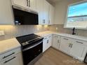 Modern kitchen featuring white cabinets, quartz countertops, and stainless steel appliances at 1003 Farm Branch Ct, Indian Trail, NC 28079