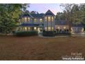 Two story house with wrap around porch, lights on at 2720 Lentz Rd, China Grove, NC 28023