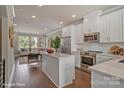 Open concept kitchen with island, stainless steel appliances, and hardwood floors at 3016 Loso Ter # 53, Charlotte, NC 28217
