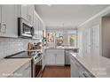 Modern kitchen features white cabinets, quartz countertops, and stainless steel appliances at 3016 Loso Ter # 53, Charlotte, NC 28217