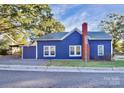 Blue house exterior with a brick chimney and gravel driveway at 275 S Church St, Mooresville, NC 28115