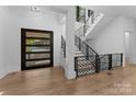 Bright entryway with modern staircase and hardwood floors at 13702 Sage Thrasher Ln, Charlotte, NC 28278