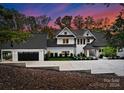 Luxury home exterior at dusk, showcasing architecture and landscaping at 13702 Sage Thrasher Ln, Charlotte, NC 28278