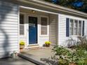 Inviting front porch with blue door, yellow mums, and a welcome mat at 2176 Old Hickory Grove Rd, Mount Holly, NC 28120