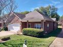 Brick ranch home with attached garage and landscaping at 104 Aberdeen Dr, Troutman, NC 28166