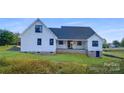 White farmhouse style home with gray roof and brick base at 615 Sandycrest Dr, Cherryville, NC 28021