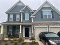 Two-story house with gray siding, stone accents, and a two-car garage at 177 Rhuidean Ct, Troutman, NC 28166