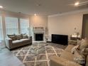 Spacious living room with a fireplace, large windows, and comfortable seating at 177 Rhuidean Ct, Troutman, NC 28166