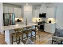 Modern kitchen with white cabinets, quartz countertops, and a large island with seating at 1044 Bull Dog Ln, Wingate, NC 28174