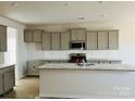 Modern kitchen featuring gray cabinets, granite countertops, and an island at 1053 Bull Dog Ln, Wingate, NC 28174
