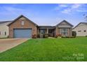 Brick ranch home with attached garage and landscaped lawn at 499 Granite Lake Ct, Denver, NC 28037