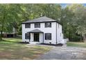 Two-story house with white brick, black trim, and a well-manicured lawn at 8946 Glencroft Rd, Mint Hill, NC 28227