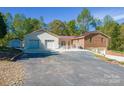 Home exterior showcasing a large driveway and detached garage at 5076 Nc Hwy 127 Hwy, Taylorsville, NC 28681