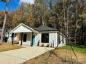 Newly built house featuring gray siding, a teal door, and a spacious front yard at 1712 Mcdonald St, Charlotte, NC 28216