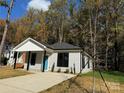Newly built house featuring gray siding, a teal door, and a spacious front yard at 1712 Mcdonald St, Charlotte, NC 28216