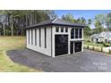 Modern concrete garage with black metal roof and large glass doors at 248 Singleton Rd # 25, Mooresville, NC 28117