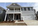 Two-story house with gray siding, stone accents, and a two-car garage at 5234 Verona Rd # 79, Charlotte, NC 28213