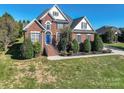 Two story brick home with blue door and landscaping at 4108 Cheshire Glen Dr, Monroe, NC 28110