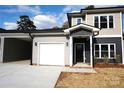 Two-story home with gray and beige siding, white garage door, and a black front door at 1022 W C St, Kannapolis, NC 28081