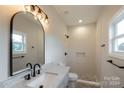 Contemporary bathroom with a walk-in shower, granite countertop, and arched mirror at 204 Wetmore Rd, Woodleaf, NC 27054