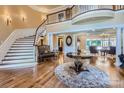 Elegant two-story foyer featuring a grand staircase, hardwood floors, and a view into the living room at 4221 Satterwythe Ln, Charlotte, NC 28215