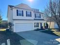 Two-story house with beige vinyl siding, a white double-door garage, and a brick base at 5536 Stowe Derby Dr, Charlotte, NC 28278