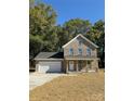Two-story brick home with a covered porch and attached garage at 1018 Cross Creek Dr, Oakboro, NC 28129
