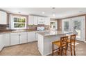 Bright kitchen with white cabinets, granite island, and tile flooring at 4108 Scarlet St, Matthews, NC 28104
