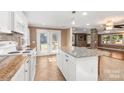 Open kitchen boasts granite counters, white cabinets, and views to the dining area at 4108 Scarlet St, Matthews, NC 28104