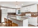 White kitchen features granite countertops and an island with seating at 4108 Scarlet St, Matthews, NC 28104