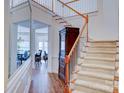 Elegant staircase with hardwood floors and a view into dining area at 6416 Red Maple Dr, Charlotte, NC 28277