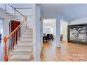 Elegant staircase with hardwood floors and a view into dining area at 6416 Red Maple Dr, Charlotte, NC 28277