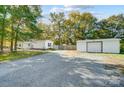 Mobile home with detached shed and spacious gravel driveway at 6924 Plyler Mill Rd, Monroe, NC 28112