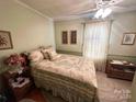 Cozy bedroom with floral bedding, nightstand, and ceiling fan at 16409 Silver Rd, Oakboro, NC 28129