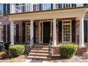Elegant front porch with brick columns and black door at 9440 Wallace Pond Dr, Huntersville, NC 28078