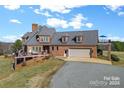 Brick home with attached garage, deck, and beautiful landscaping at 590 Tuckertown Rd, New London, NC 28127