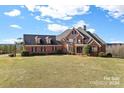 Brick home with large windows, dormers, and a spacious lawn at 590 Tuckertown Rd, New London, NC 28127