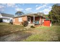 Brick ranch home with a covered porch and storage shed at 131 E Branch Ave, Shelby, NC 28152
