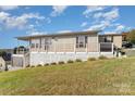 Elevated home with deck, railings, and landscaping; offering lake views at 127 Lake View Dr, New London, NC 28127