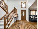 Two-story foyer with hardwood floors, wooden staircase, and a console table at 16008 Samar Ct, Tega Cay, SC 29708