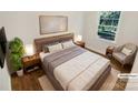 Virtually staged bedroom with hardwood floors and large window at 2614 Bancroft St, Charlotte, NC 28206