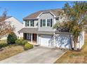 Two-story house with gray siding, two-car garage, and landscaping at 620 Smokehouse Ln, Albemarle, NC 28001