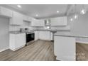 Modern kitchen featuring white cabinets, granite countertops, and stainless steel appliances at 728 Jefferson Ave, Rock Hill, SC 29730