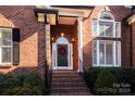 Brick home front entrance with wreath and steps at 11411 Home Place Ln, Mint Hill, NC 28227