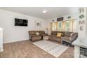 Living room with hardwood floors, brown sectional sofa, and large TV at 14034 Clayborn St # 28, Midland, NC 28107